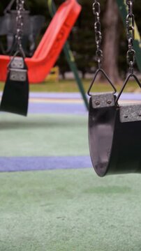 Close up of empty swing moving in playground vertically