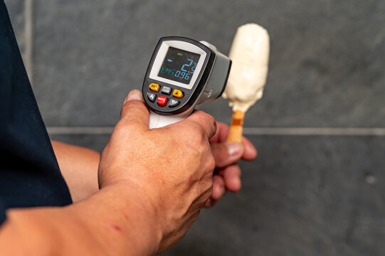 Checking Ice Cream Temperature with Infrared Laser Thermometer,Measuring Frozen Dessert Temperature with Pyrometer,Hand Holding Infrared Thermometer and Ice Cream