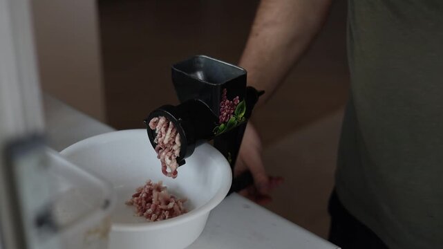Raw pork is minced in meat grinder