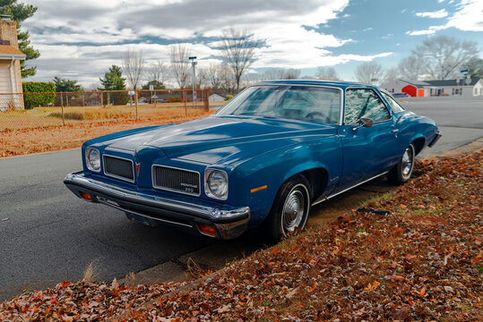 Retro vintage Pontiac LeMans 1973 parked curbside showing chrome grille and headlights
