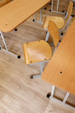 Empty wooden chair and desks in school classroom interior. Primary education furniture background. Back to school concept, elementary learning workspace, classroom, nobody, indoor, study, room