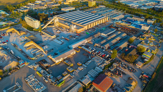 Aerial view of the Malesice Infrastructure Objects industrial complex with large warehouses, storage yards, and parked vehicles in Hlavni mesto Praha, Hlavni mesto Praha, Czechia.