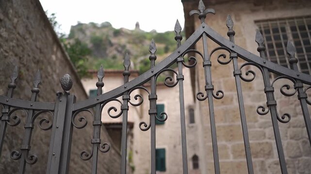 Closeup of intricately crafted iron gate with rustic background