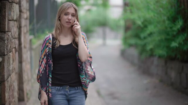 Young Woman Walking Outdoors Talking On Phone Representing Communication Lifestyle Mobile Technology And Everyday Interaction In Urban Environment