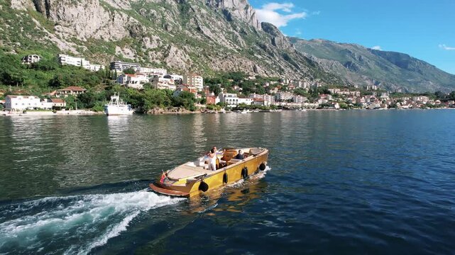 Vibrant boat journey. Colorful vessel sailing nearby coast. Sunny yellow boat gliding past shoreline structures