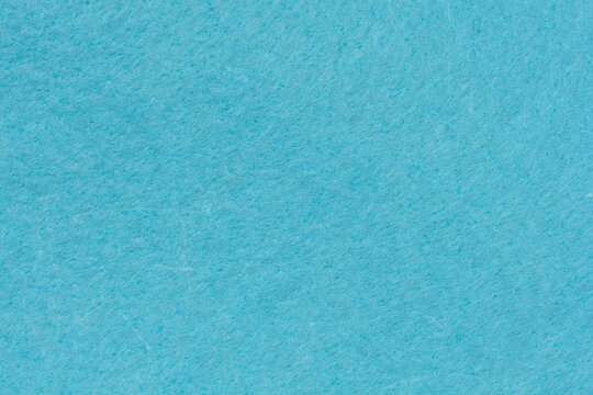 A close up top view of a light blue felt fabric surface showing a soft and fuzzy non woven textile texture