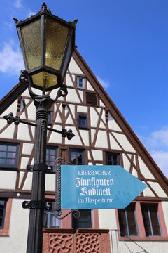 Signpost points to Eberbach's figurine cabinet near the Haspelturm in Germany during a sunny day
