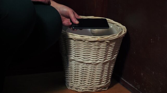 Hands putting mobile phone in the bin