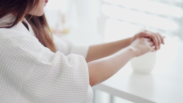 Asian women hand reaching out touching air purifier humidifier device white modern home interior wellness lifestyle healthy living morning routine technology