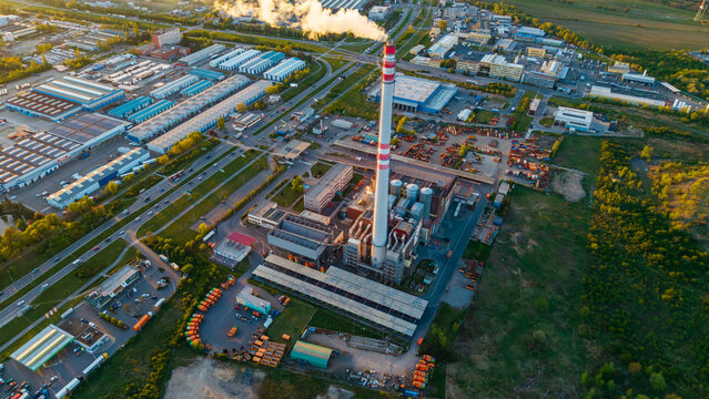 Aerial view of Malesice Infrastructure Objects with a tall chimney and industrial warehouses during golden hour in Hlavni mesto Praha, Hlavni mesto Praha, Czechia.