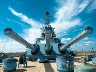 Group of three World War Two 16 inch battleship guns and turret against blue sky and clouds © Gerald Zaffuts
