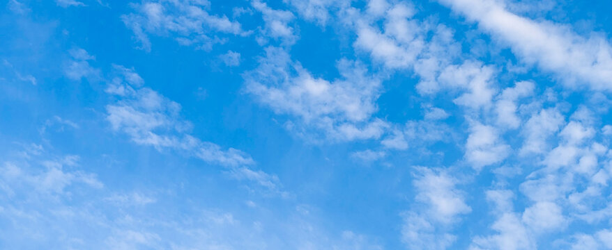 Bright blue sky with scattered white clouds on clear day.