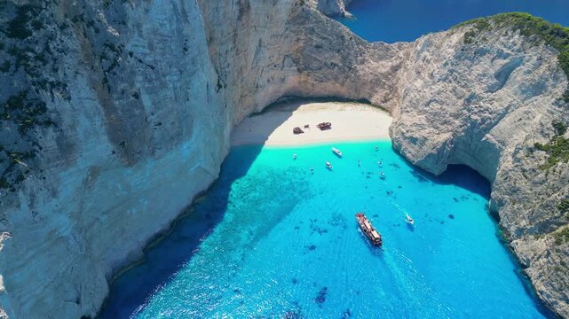 Spectacular view of the iconic Shipwreck beach in Navagio Bay, Zakynthos. Famous rusted boat on white sand surrounded by massive limestone cliffs and turquoise Ionian Sea water.