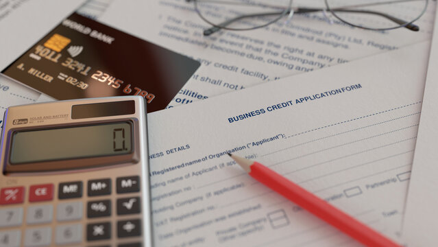 Business credit application form with pencil, calculator and glasses on desk