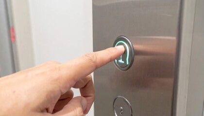 Naklejka premium Closeup Hand Pressing Illuminated Elevator Button on Metal Control Panel