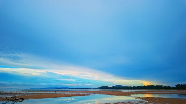 Time lapse footage highlights dynamic cloud movement during a tropical sunset, creating a breathtaking reflection across still waters in Phuket Thailand. Colorful Twilight Clouds Over Remote Island.