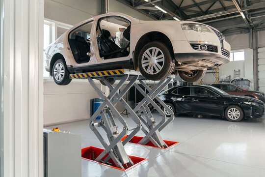 Car on hydraulic lift at auto repair shop. Auto sevice concept