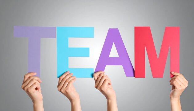 Colorful Team Letters Held by Hands Against Gray Studio Background