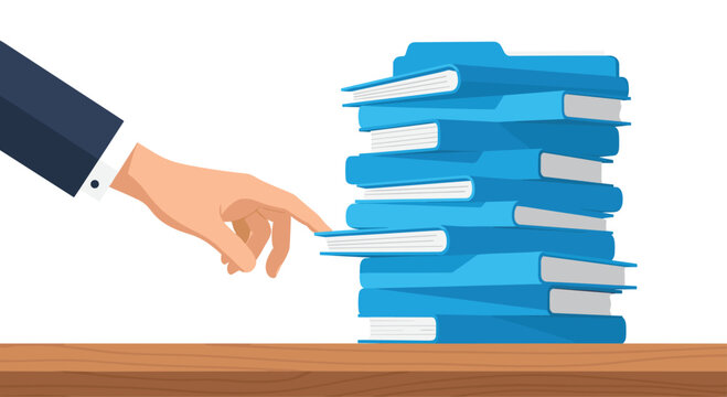 A human hand reaches toward a tall, precarious stack of bright blue office file folders sitting on a polished wooden desk surface against a white backdrop.