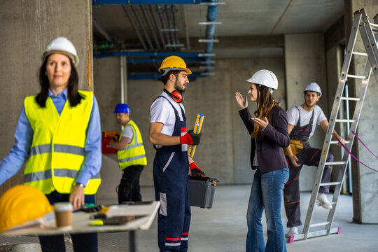 Female architect shouting and criticizing a construction worker on a renovation site.