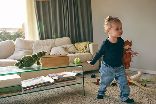 Cute girl playing with toys in living room at home