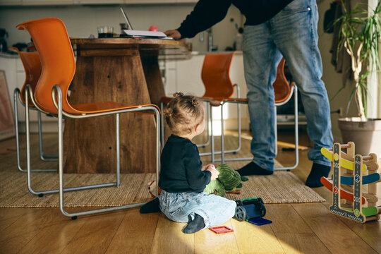Full length of girl playing with toys while sitting on floor in home