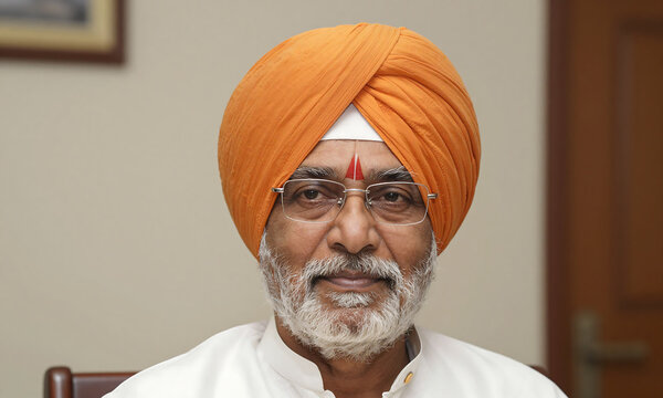 warm portrait mature indian man orange turban wrapped around head bespectacled face neutral indoor