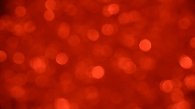 Close-up of red bokeh light particles on dark gradient background