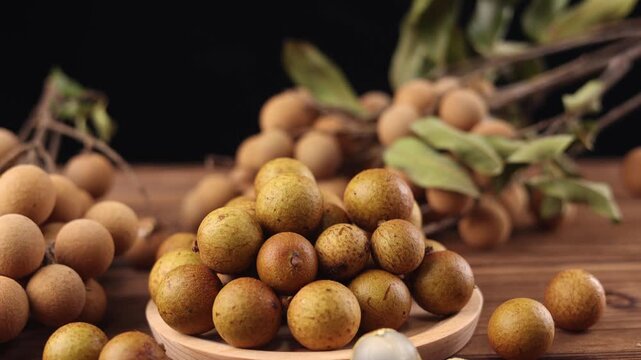 Fresh Longan Fruit on Wooden Plate with Leaves