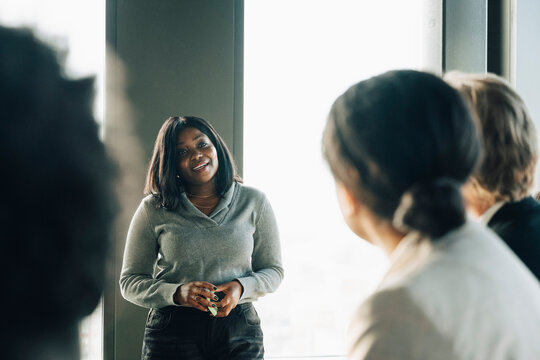 Female entrepreneur giving presentation to coworkers at startup workspace