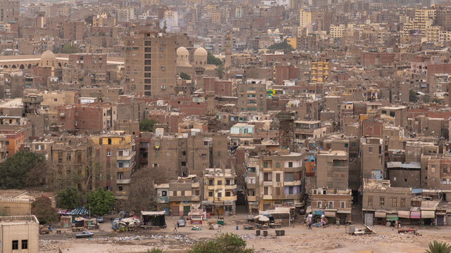 Cairo cityscape features dense residential buildings and historical domes. Urban development with crowded infrastructure and living spaces