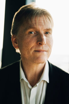 Close-up portrait of confident male investor in blazer at office