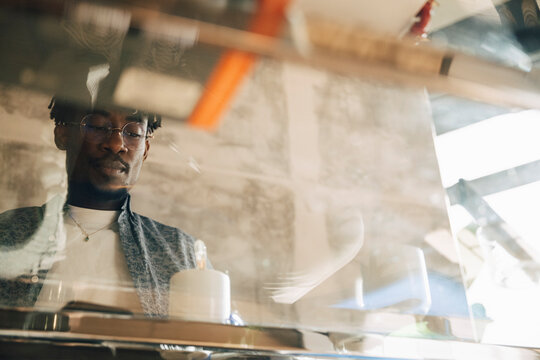 Low angle view of businessman seen through glass desk at office