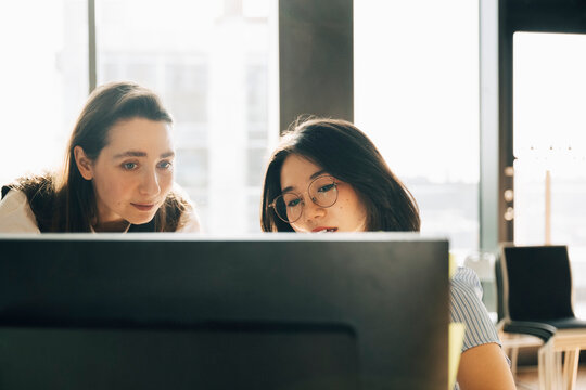 Businesswomen working together on desktop PC at creative workspace
