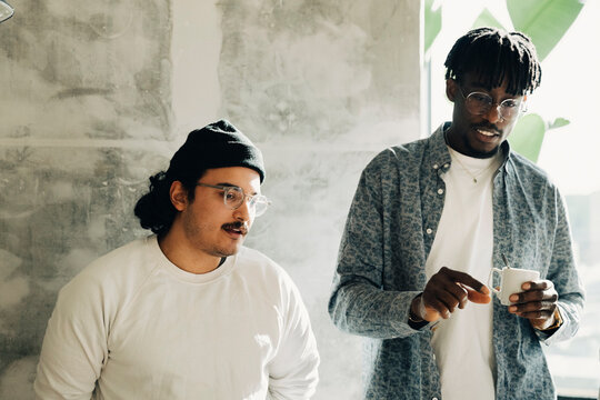 Diverse male entrepreneurs against gray wall at modern startup office