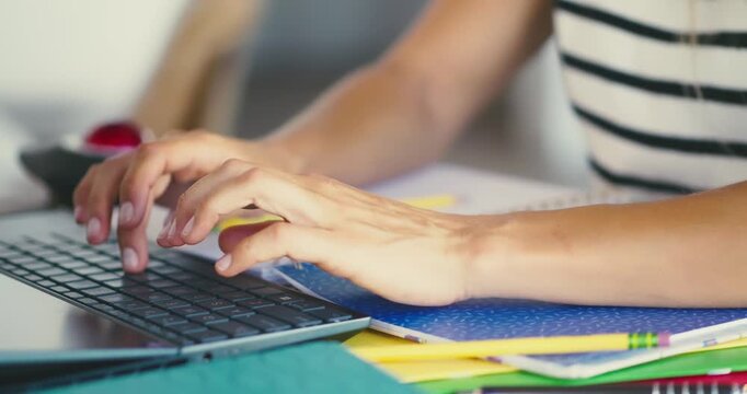 Woman Typing on Laptop at Desk in Office