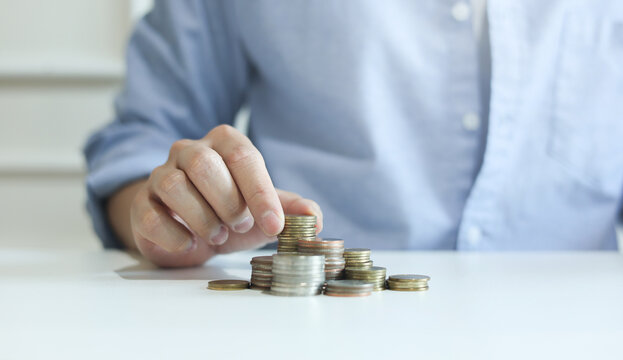 close up man hand stack coin for investment about lifestyle or family or health and wealth retirement concept