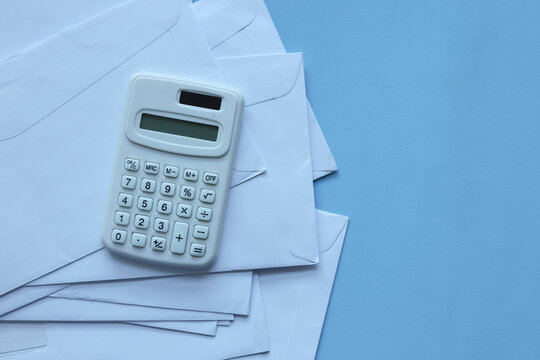 close up top view on calculator and open over calculator and group of invoice letter mail and from bank on beige table background for money and debt management concept