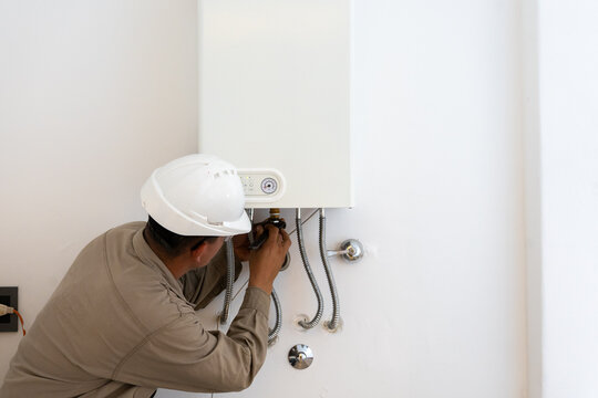 Gas water heater boiler installed in domestic kitchen near window for safety ventilation