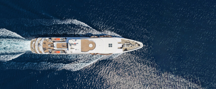Aerial drone ultra wide panoramic photo with copy space of luxury yacht with wooden deck cruising near port Port Hercules in deep blue sea, Monaco, France