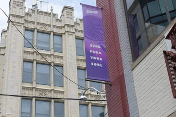 Naklejka premium wall mounted projecting banner outside The Ballroom Bowl, with view of historic 299 Queen St W, Toronto