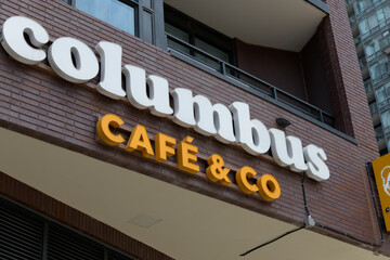 Naklejka premium building exterior and sign of Columbus Café, a coffee shop chain, located here at 283 Adelaide St W, Toronto