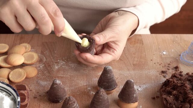 Filling traditional no-bake Czech Christmas cookies called beehives or wasp nests with homemade cream