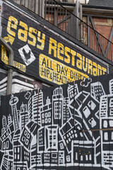 Naklejka premium funky signage outside Easy Restaurant located at 1645 Queen St W, Toronto