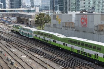 Naklejka premium looking east over the Union Station Rail Corridor with Go Train and signs near CN Tower, Toronto
