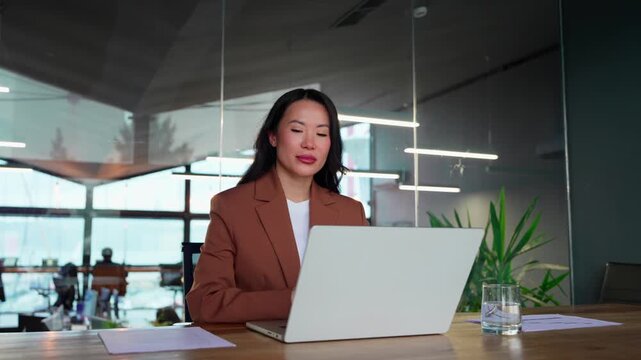 Portrait of professional executive CEO woman working on laptop in office at business workplace. Beautiful woman smiling at camera. Asian confident mature good looking middle-age leader female manager