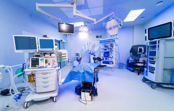 Empty high tech hospital surgery room with monitors and robot. Interior of a modern surgical department featuring robotic systems and life support monitors.