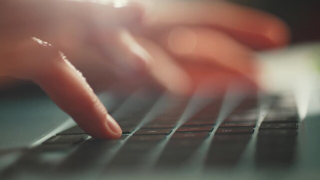 Close-up of female hands typing fast on a laptop keyboard