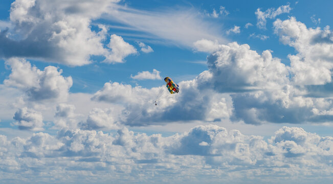 Parasailing sport activity. Parachute in the sky. Extreme rest and parasailing. Summer vacation. Sea sport. Parachute parasail. Water sport on summer vacation. Parasailing recreation with parachute