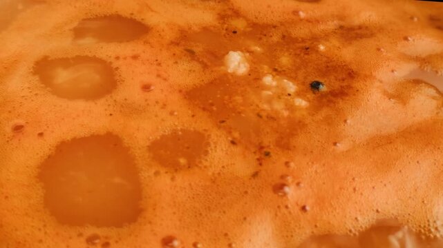 kharcho soup boiling and cooking close up, hot pot with greens rice and spoon spinning in a circle, georrgian restaurant, tomato soup macro. 